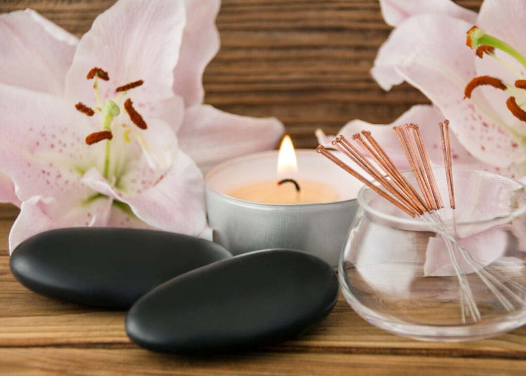 Candle with scent sticks and hot massage therapy stones